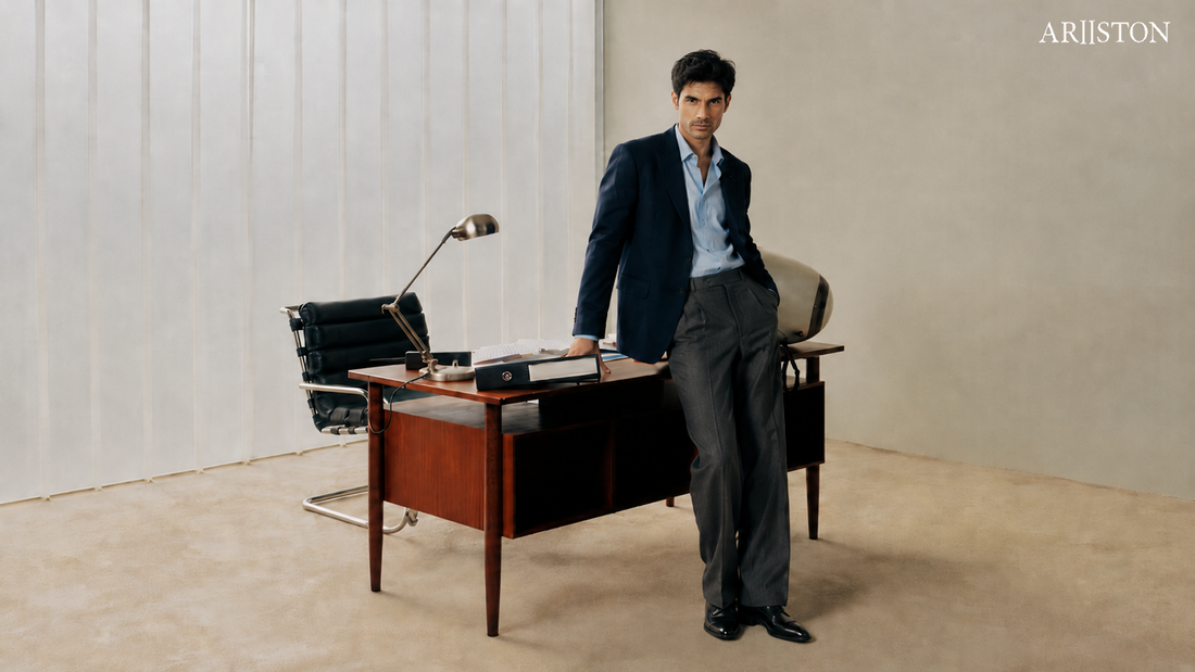 Man in a navy suit beside an office desk